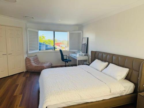 a bedroom with a bed and a desk with a computer at Spacious Family Retreat with Pool in Carindale in Brisbane