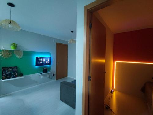 een kamer met een tv aan de muur en een kamer met bij Apartamento aconchegante e tranquilo Suzano in Suzano