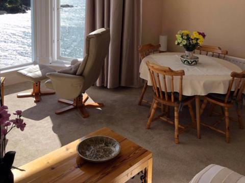 ein Wohnzimmer mit einem Tisch und einem Stuhl in der Unterkunft St Catherines Court No 7 in Fowey