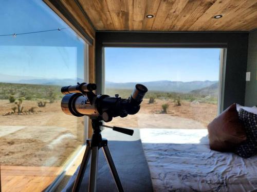 a camera on a tripod in a room with a window at Stunning Tiny House with Picnic Space, Barbecue and Fire Pit in Meadview, Arizona in Ray Place
