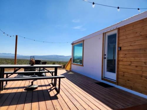 a wooden deck with a picnic table and a tent at Stunning Tiny House with Picnic Space, Barbecue and Fire Pit in Meadview, Arizona in Ray Place
