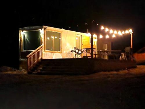 a tiny house with a bike parked outside at night at Stunning Tiny House with Picnic Space, Barbecue and Fire Pit in Meadview, Arizona in Ray Place