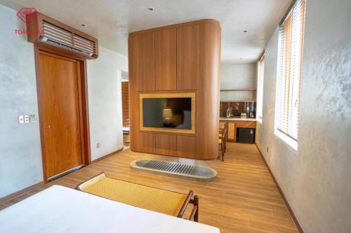 a living room with a flat screen tv on a wall at Toàn Cầu Hotel Quảng Bình in Dong Hoi
