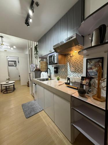 eine Küche mit Geräten aus Edelstahl und einer großen Theke in der Unterkunft JA2 STAYCATION @TREES RESIDENCES in Manila