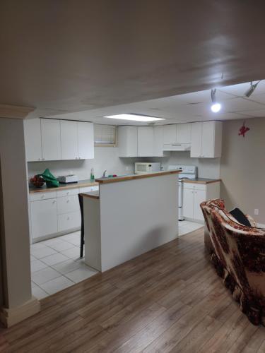 a kitchen with white cabinets and a table and a couch at A Place to Call Home in Edmonton