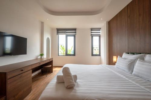 a bedroom with a large white bed and a television at La Hotel Nguyen Van Dung in Ho Chi Minh City