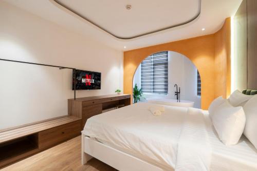 a bedroom with a bed and a tub and a television at La Hotel Nguyen Van Dung in Ho Chi Minh City