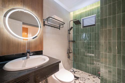 a bathroom with a sink and a mirror and a shower at La Hotel Nguyen Van Dung in Ho Chi Minh City
