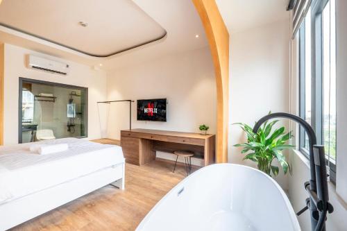 a bathroom with a bed and a desk and a tub at La Hotel Nguyen Van Dung in Ho Chi Minh City