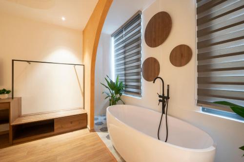 a bathroom with a white tub and a window at La Hotel Nguyen Van Dung in Ho Chi Minh City