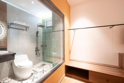 a bathroom with a glass shower and a toilet at La Hotel Nguyen Van Dung in Ho Chi Minh City