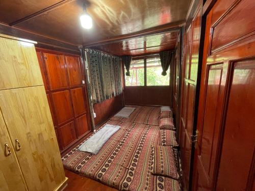 an empty train car with a bed in a room at Sông Quê Homestay in Quảng Uyên