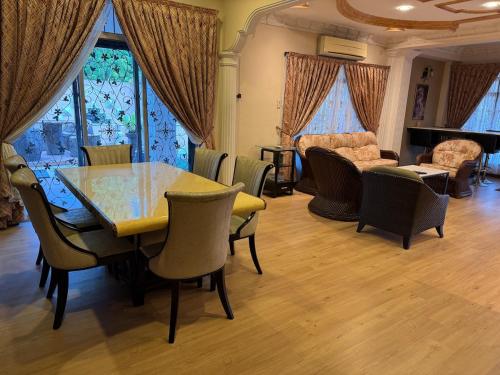 a dining room with a table and chairs and a couch at Kas Villa Homestay JB in Johor Bahru