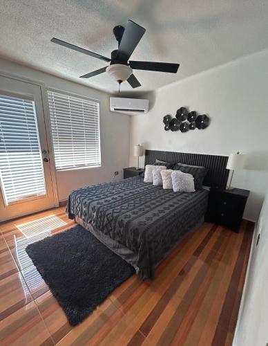 a bedroom with a bed with a ceiling fan at Estudio práctico y confortable en segundo piso in Senecú