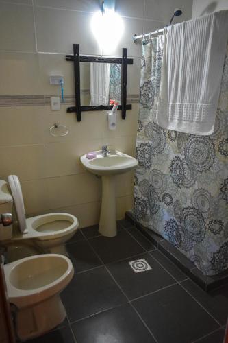 Un baño con inodoro, lavabo y ducha. en Casona en Balneario Las Can̈as, en Fray Bentos