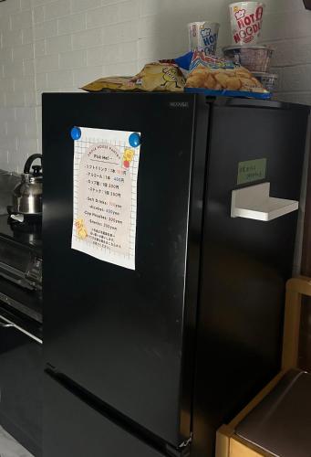 a black refrigerator with a piece of paper on it at FLORAhouse in Oita