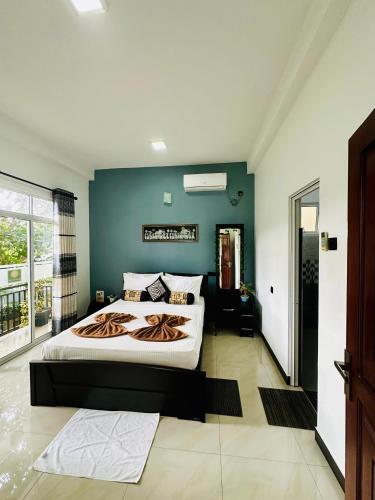 a bedroom with a large bed and a blue wall at Mountain White Villa by Sunrise in Kandy