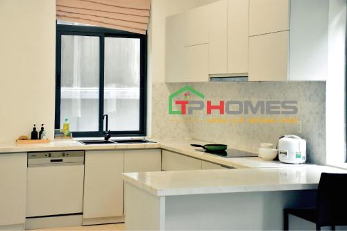 a kitchen with white cabinets and a sign on the wall at TP-HOMES in Ho Chi Minh City