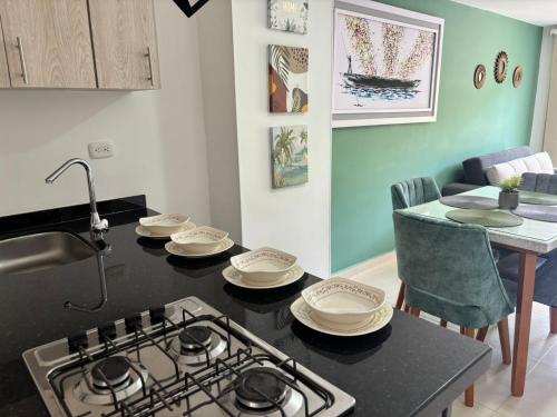 a kitchen with a stove and a table with plates on it at Full Apartamento de descanso vacacional in San Gil