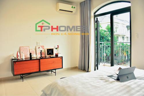 a bedroom with a bed and a laptop on a desk at TP-HOMES in Ho Chi Minh City