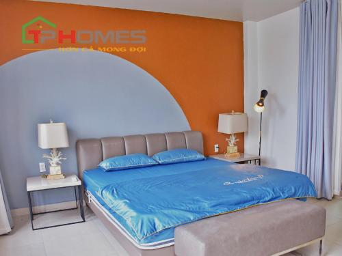 a bedroom with a large bed with blue sheets at TP-HOMES in Ho Chi Minh City