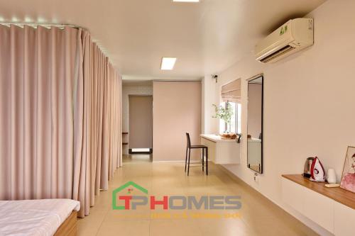 a bedroom with a bed and a desk with a chair at TP-HOMES in Ho Chi Minh City