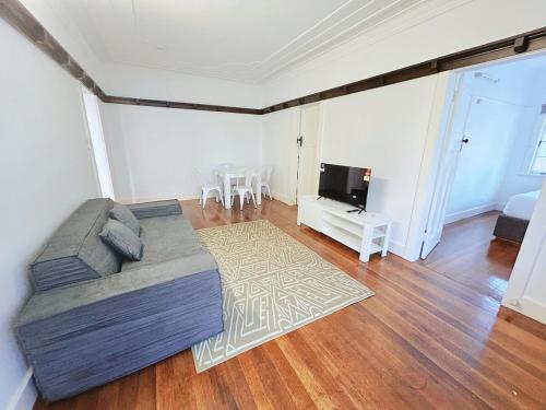 a living room with a couch and a flat screen tv at Walk to Southbank Brisbane City Art Deco House in Brisbane