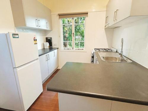 a kitchen with a white refrigerator and a sink at Walk to Southbank Brisbane City Art Deco House in Brisbane