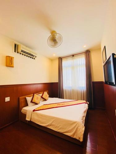 a bedroom with a bed with a television and a window at Hồng Ngọc Hotel Tuy Hòa in Tuy Hoa
