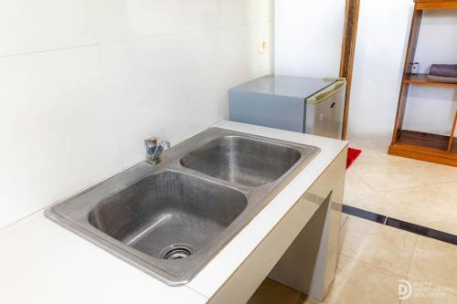 a stainless steel sink in a kitchen with a refrigerator at Menjangan View in Banyuwedang