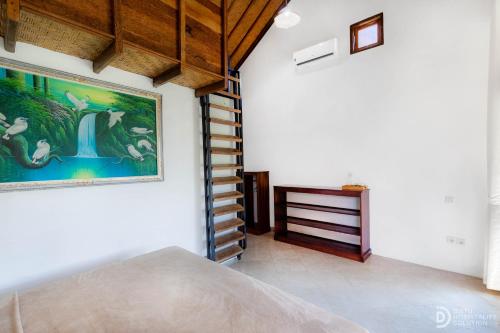 a bedroom with a painting on the wall and a staircase at Menjangan View in Banyuwedang