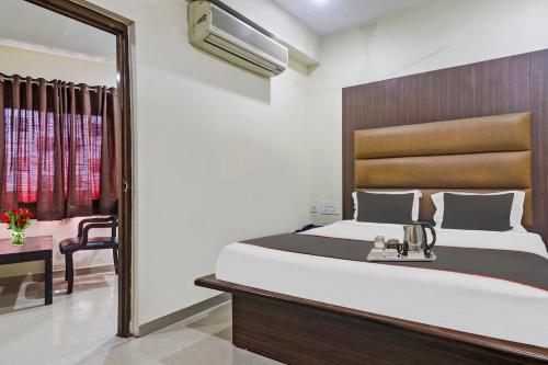 a bedroom with a large bed and a mirror at Collection O THE CROWN HOTEL in Hyderabad