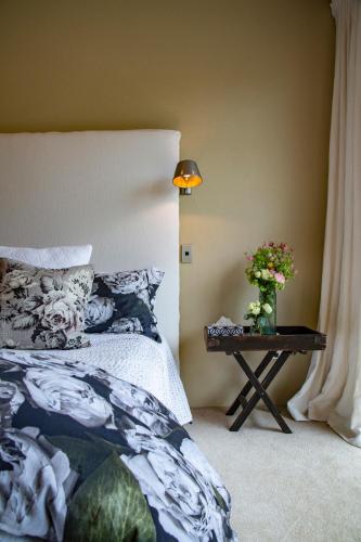 ein Schlafzimmer mit einem Bett und einem Tisch mit Blumen in der Unterkunft Nga Pari Vineyard in Gladstone