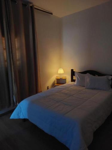a bedroom with a large bed with a blue blanket at Pousada Jardim Alterosa in Vespasiano