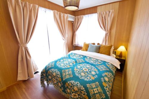 ein Schlafzimmer mit einem Bett und einem großen Fenster in der Unterkunft 北谷町宮城戸建て in Hamakawa