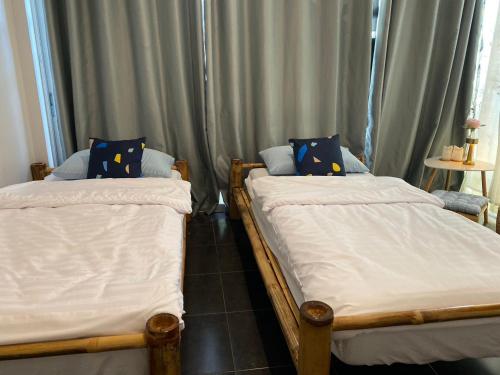 two twin beds in a room with curtains at baan in kan homestay&cafe kanchanaburi city in Kanchanaburi