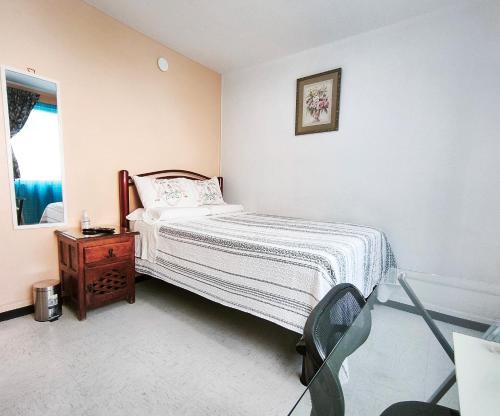a bedroom with a bed and a table and a mirror at Cozy bedroom at 5 min Mexico City Airport T1 & T2 in Mexico City