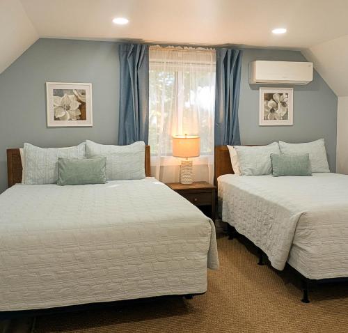 two beds in a bedroom with blue walls at Beautiful Bar Harbor House in Bar Harbor