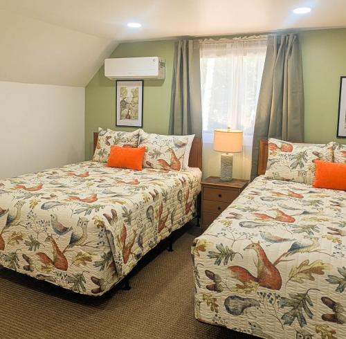a bedroom with two beds with orange pillows at Beautiful Bar Harbor House in Bar Harbor