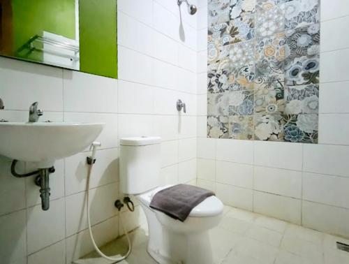 Un baño con un inodoro blanco y un lavabo. en RedDoorz at Flory Hotel Jalan Parangtritis, en Timuran
