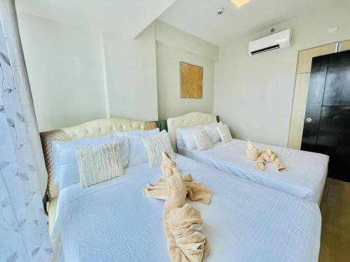 a bedroom with two beds with stuffed animals on them at Heart of Mactan Newtown big space with free wifi and pool access in Punta Engaño
