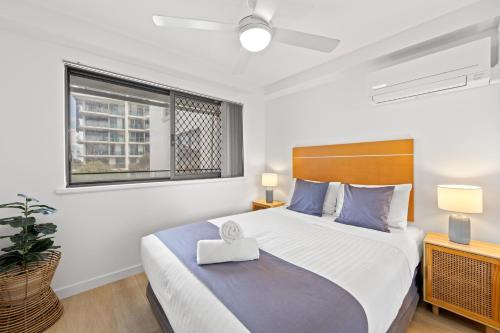 a bedroom with a large bed and a window at Windward Apartments in Mooloolaba