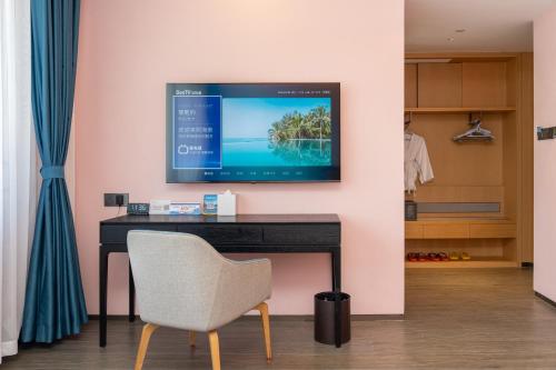 Una televisión o centro de entretenimiento en Sanya Junji Seaview Hotel