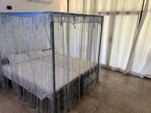 a small bed in a room with curtains at Sri Holiday House - Hikkaduwa in Hikkaduwa