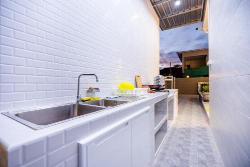 een keuken met een wastafel en een witte bakstenen muur bij Love U Pool Villa Hua Hin-Pet Friendly House in Hua Hin
