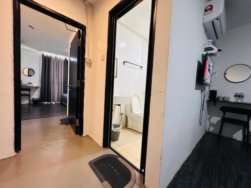 a room with a mirror and a bathroom with a toilet at Kuu Inn Hotel in Arau