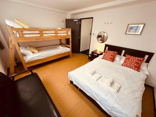 a bedroom with two bunk beds and a couch at Rest Collection SEIWA LODGE Tokyo in Tokyo