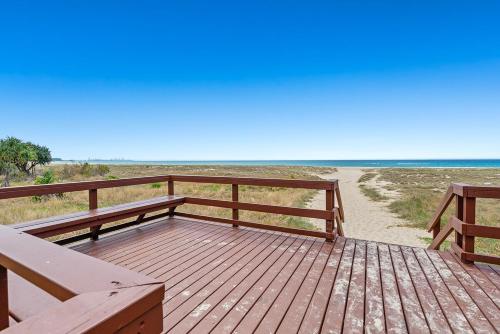 a wooden deck with two benches on a beach at Coastal Retreat at Bilinga Beach, Ocean Views in Gold Coast