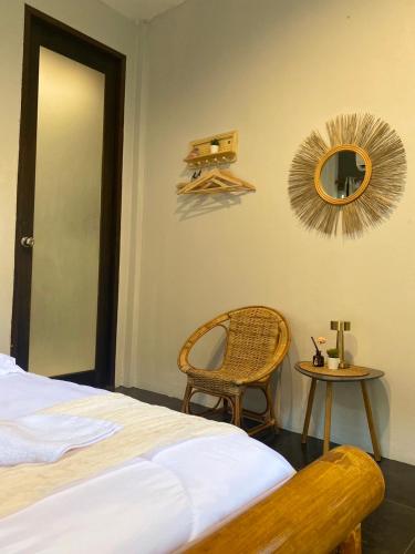 a bedroom with a bed and a chair and a mirror at baan in kan homestay&cafe kanchanaburi city in Kanchanaburi City