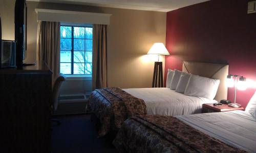 
a hotel room with a bed and two lamps at Fireside Inn & Suites West Lebanon in West Lebanon
